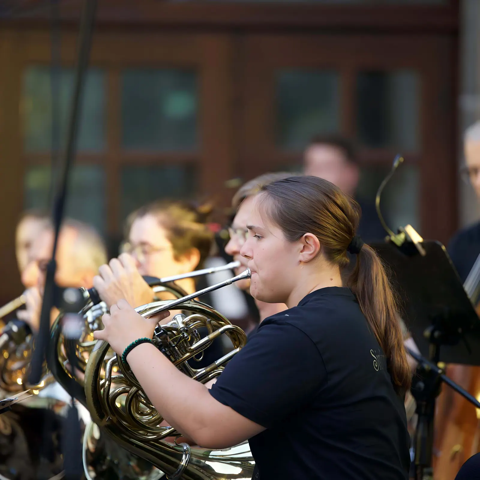 Eine junge Hornistin spielt im Orchester